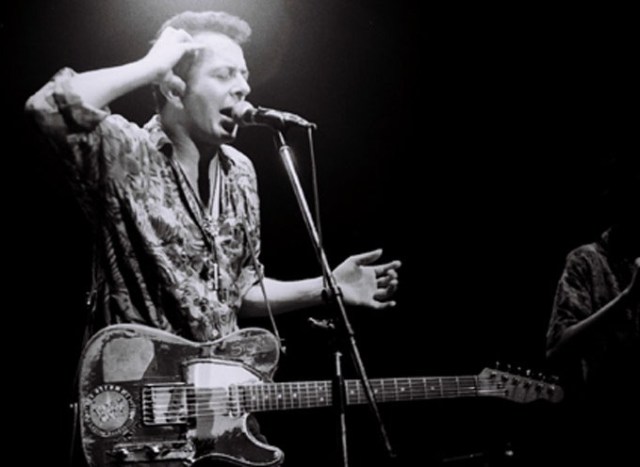 Joe Strummer, playing with the Pogues (photo by Masao Nakagami)